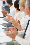 Business people clapping colleague at a meeting