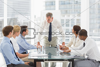 Stern businessman looking down at his staff during a meeting