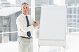Smiling businessman standing at whiteboard with marker