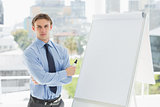 Young stern businessman standing by whiteboard