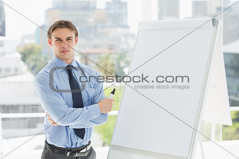 Young stern businessman standing by whiteboard