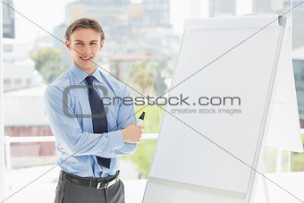 Young happy businessman standing by whiteboard