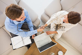 Business team working together on the couch shaking hands