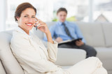 Happy businesswoman on the phone sitting on couch