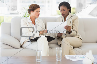 Businesswomen planning together on the sofa