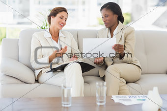 Businesswomen planning together on the sofa and laughing