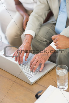 Salesman showing something on laptop to couple