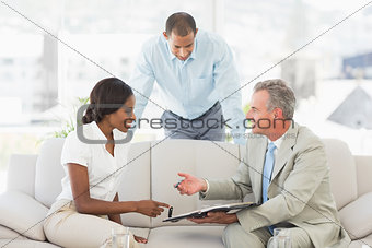 Salesman showing clients where to sign the contract