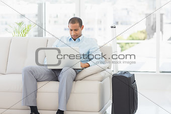 Businessman using laptop waiting to depart on business trip