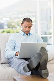 Businessman using laptop with his feet up