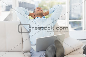 Relaxed businessman on the couch with laptop