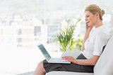 Businesswoman sitting on the sofa with laptop