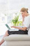 Businesswoman sitting on the couch with laptop