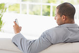 Businessman reading a text on the couch