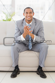 Excited businessman sitting on couch
