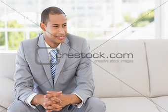 Smiling businessman sitting on sofa