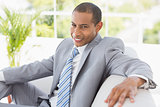 Businessman sitting on couch smiling at camera