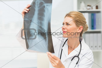 Doctor examining an xray sitting at her desk