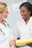 Doctor and nurse going over file together smiling at each other