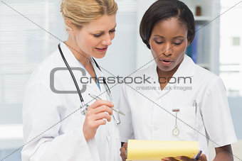 Happy doctor and nurse going over file together