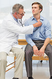 Doctor listening to his patients chest with stethoscope