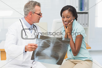 Doctor showing young patient her positive chest xray
