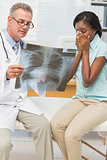 Doctor showing pleased patient her positive chest xray