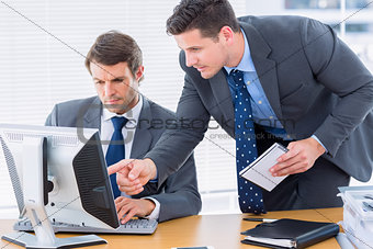 Businessmen using computer at office desk