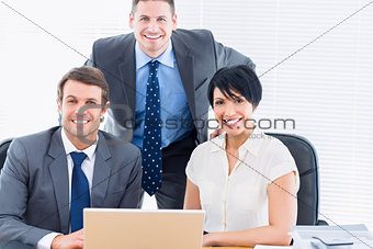 Colleagues with laptop at office desk