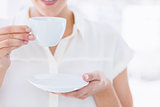 Mid section of a businesswoman with tea cup