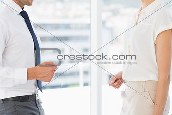 Mid section of executives exchanging business card