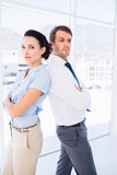 Young business couple standing with arms crossed
