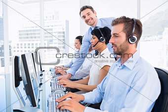 Manager and executives with headsets using computers