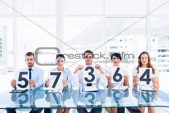 Group of panel judges holding score signs