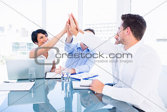 Executives giving high five in a business meeting