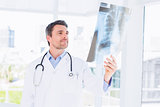 Serious male doctor examining xray