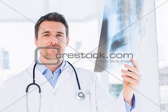 Portrait of a male doctor examining xray