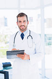Portrait of a confident male doctor with clipboard
