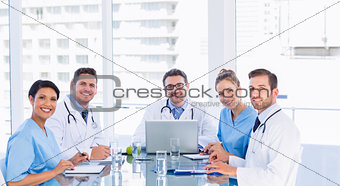 Smiling medical team around desk in office