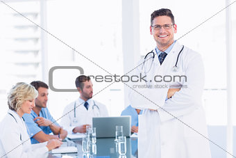 Smiling doctor with colleagues in meeting