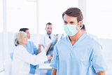 Male surgeon wearing mask with colleagues in meeting
