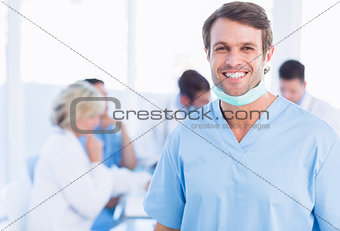 Smiling male surgeon with colleagues in meeting