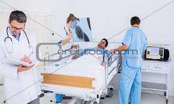 Doctors holding reports by patient in at hospital