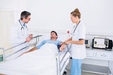 Doctors visiting a male patient in hospital