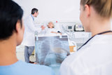 Rear view of doctors with blurred patient in hospital
