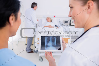 Doctors examining xray with blurred patient in background