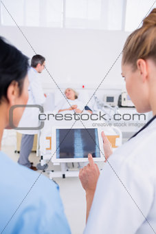 Doctors examining xray with blurred patient in background