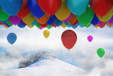 Many colourful balloons above snow