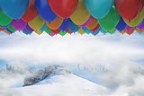 Many colourful balloons above snow