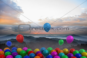 Many colourful balloons above landscape